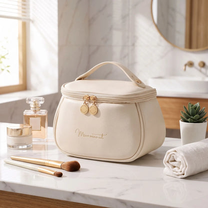 trousse de toilette de couleur crème posée  sur un plan blanc 