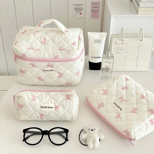 Trousse de toilette 3 formats démontrés posée sur une table blanche 