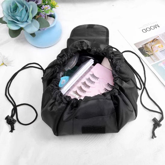 Trousse de toilette couleur noire posée sur une plan blanc