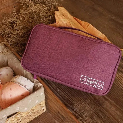 Trousse de toilette couleur rouge cerise posée sur une table en bois 