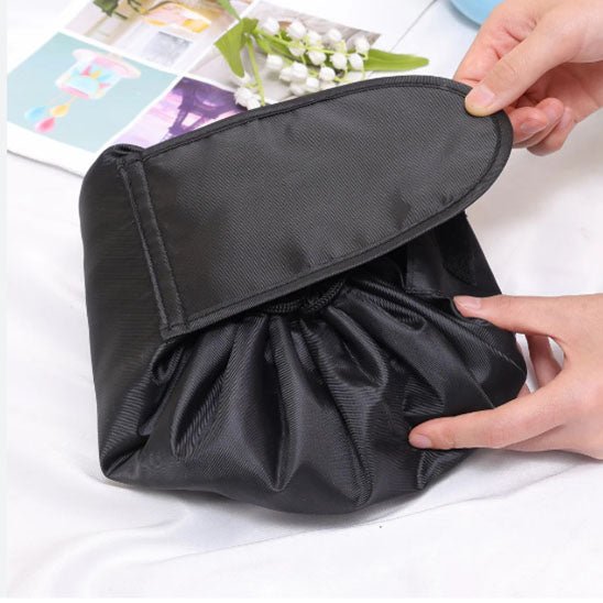 Une femme qui referme la trousse de toilette fourre-tout couleur noire 