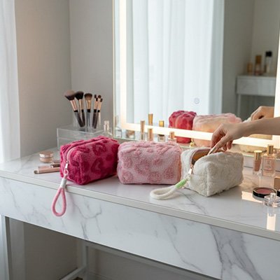 Trousse de toilette les 3 coloris posé sur un plan blanc 