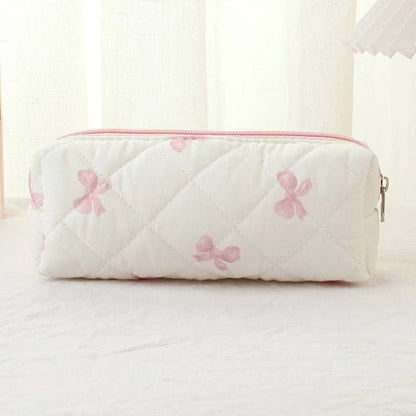 Trousse de toilette petit format posée sur un plan blanc