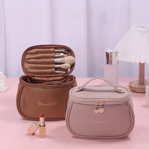 Trousse de toilette mini sac à main posées sur un plan rose avec accessoire de maquillage et de beauté autour