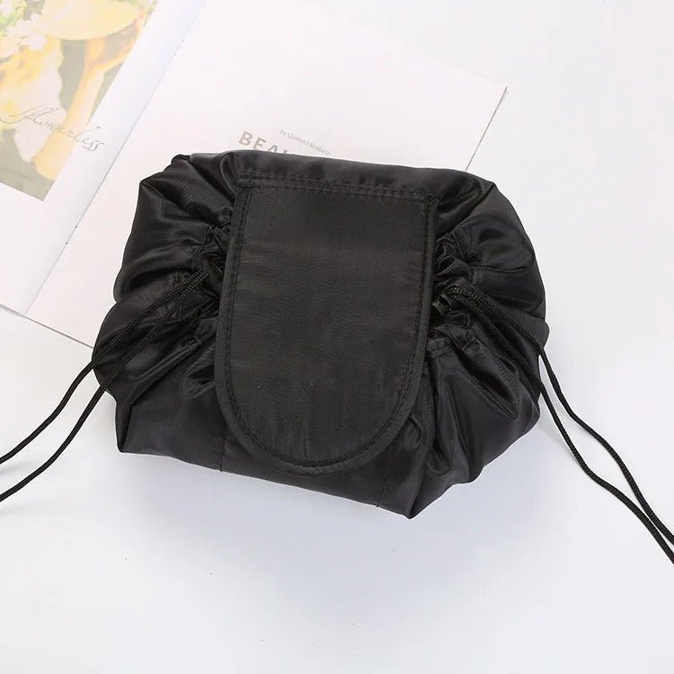 Trousse de toilette couleur noire posée sur une plan blanc