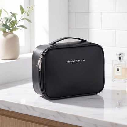 trousse de toilette noire posée sur un plan blanc et gris 
