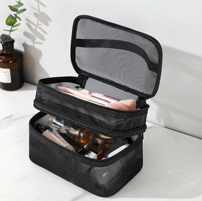 Trousse de toilette couleur noire ouverte posée sur un plan blanc
