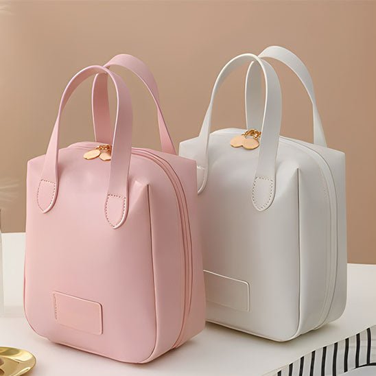 Trousse de toilette couleur rose et blanche posées sur un plan blanc 