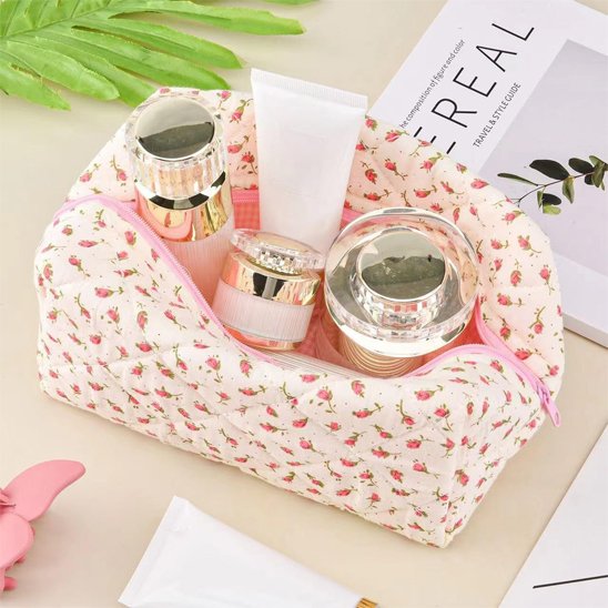 Trousse de toilette rose posée sur un plan beige