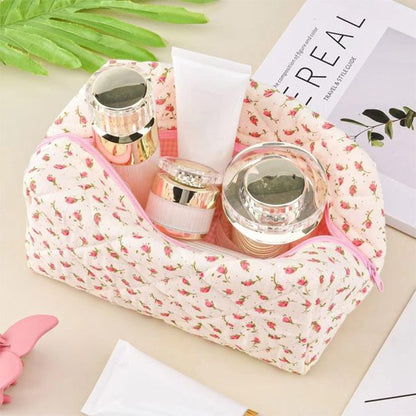 Trousse de toilette rose posée sur un plan beige