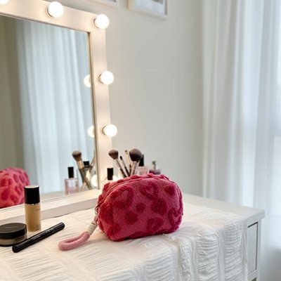 Trousse de toilette rouge posée sur une table blanche 