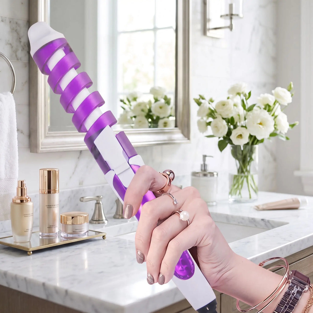 une main qui tient le boucleur couleur pourpre afin d'en apprécier toutes les caractéristiques 